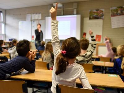 Klasseværelse hvor elev rækker hånden op 