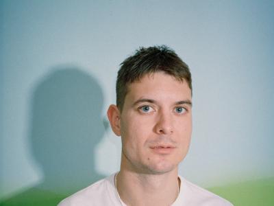 Portræt af Caspar Eric i en hvid tshirt foran en neutral baggrund