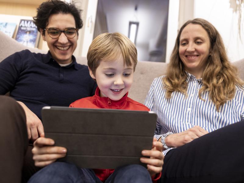 Familie sidder sammen med tablet